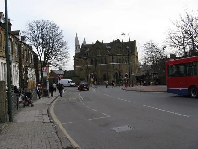 View southeast along part of Acton Lane, Harlesden, London NW10, to the junction with Station Road. The building just beyond the junction is All Souls parish church.
