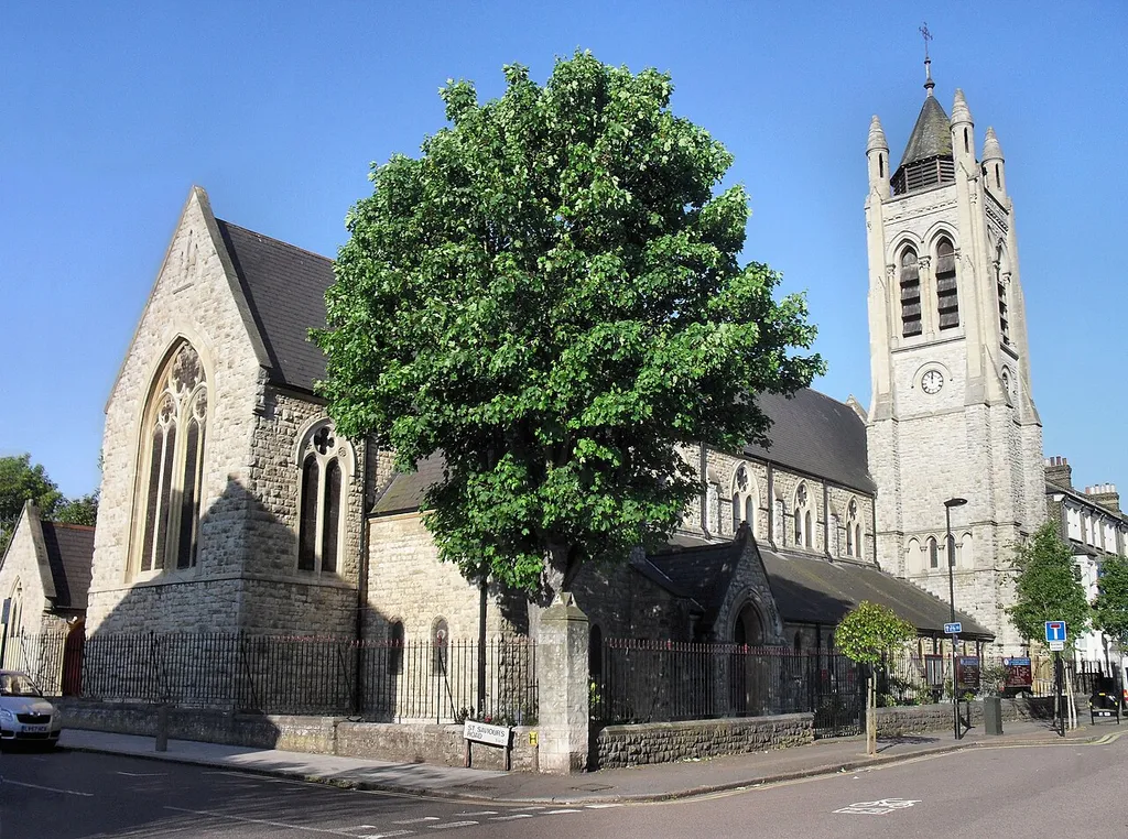 St Saviour's, Brixton Hill was, until 1977, a daughter church of St. Mathew's, Brixton. It was then declared redundant and leased to the New Testament Church of God, who extended it in 2000. In the 1870s housing development was taking place in the area north of the Windmill in Brixton Hill that had previously been meadowland and brickfields. At a meeting held at St. Matthew's vicarage on March 24, 1873, it was decided to build a new daughter church to serve a population that by then had reached of some 4,000. A site was acquired and the architect, E.C. Robins was commissioned to design the building. The church was consecrated in September 1875. Shortly afterwards an associated chapel was built in Vicary Road. The building is in in French thirteenth-century style style utilising grey Kentish ragstone with Bath stone dressings. The tower at the north-west corner has four circular corner pinnacles and an octagonal louvred lantern with a single chimed bell of 1897 that was given for Queen Victoria's jubilee. The nave has of six bays, with low, wide aisles. Sources: London Metropolitan Archives, British History On-line. The church featured as Ambrose Chapel in the 1956 film, 'The Man Who Knew Too Much'