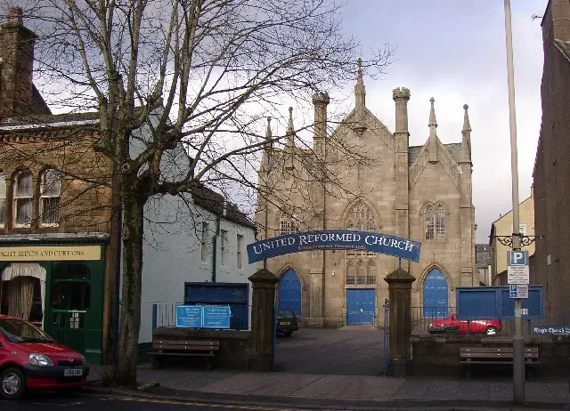 Cockermouth United Reformed Church. Founded as a Congregational Church in 1651. This building in Main Street was built in 1856, in a Perpendicular style. Behind it is a Sunday School with roughcast walls, round-headed windows to the ground floor and sash windows above, built in 1719.