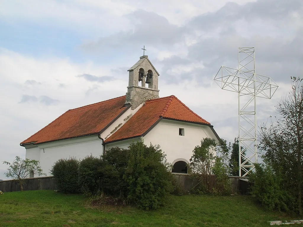 Late Gothic church from the 17th century, near the village of Zalog near Postojna. On the right is a cross erected during visit by Pope John Paul II in 1996.