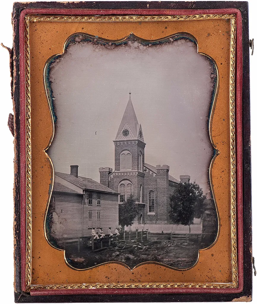 Half plate daguerreotype of the First Presbyterian Church in Niagara Falls, NY. Housed in half, pressed paper case. In the foreground, a group of people, possibly children or young adults, uniformly dressed in white sit atop the rail of an unfinished fence. This is an image of a place or building that is listed on the National Register of Historic Places in the United States of America. Its reference number is 14000145 (Wikidata).