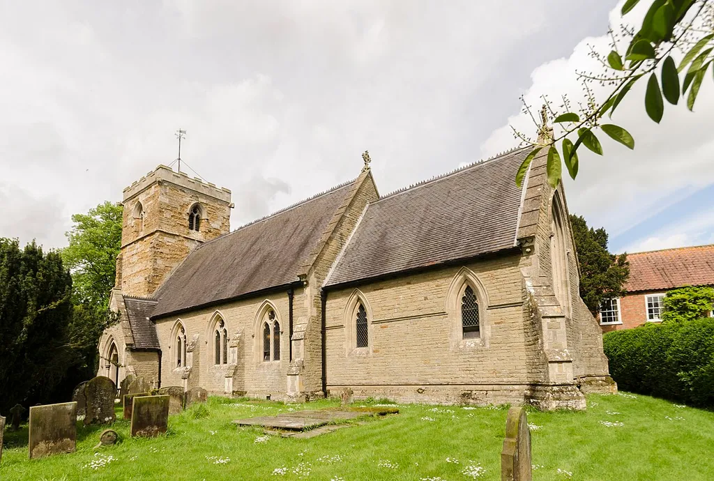 Early 14th C. church restored in 1866 by Atkinson. There was probably an earlier church. There is a western tower, nave with south porch, and chancel with vestry. The tower is of four stages dating from the early 14th century. It is built in ironstone and is quite weathered. The rest of the church is from the 19th century, replacing the church of 1766. The nave has no aisles, all the fittings date from the 19th century. There are two monuments which have survived from the 17th century.