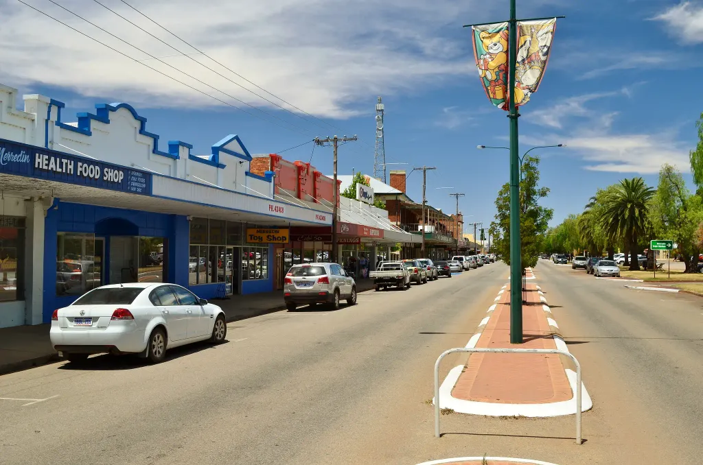 A view of Barrack Street, Merredin, Western Australia, taken from outside the (present day) Merredin railway station looking east. The two storey building near the centre of the image is the Commercial Hotel.