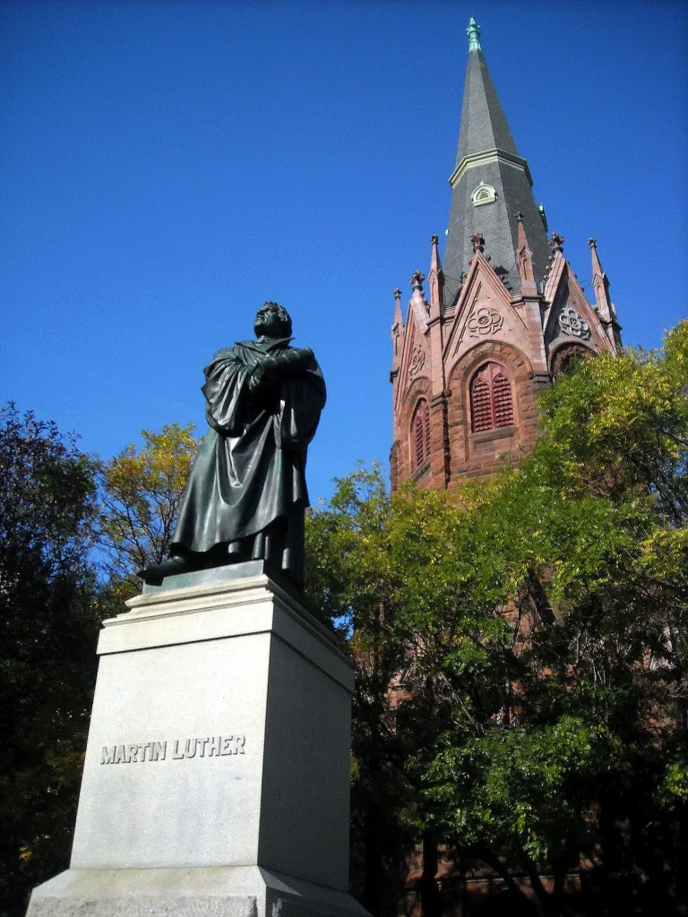 A bronze statue of Martin Luther and the octagonal tower of Luther Place Memorial Church, located on the north side of Thomas Circle, at 1226 Vermont Avenue, N.W., in the Logan Circle neighborhood of Washington, D.C. Built 1870–1873, the Gothic Revival church was designed by architect Judson York, whose design was later modified by architects John C. Harkness and Henry S. Davis. Originally known as the Memorial Evangelical Lutheran Church of Washington, D.C., the church was renamed after a replica of Ernst Friedrich August Rietschel's Lutherdenkmal (Luther Monument) in Worms, Germany, was erected on the site in 1884. Luther Place Memorial Church was listed on the National Register of Historic Places on July 16, 1973. The church and statue are contributing properties to the Fourteenth Street Historic District.
