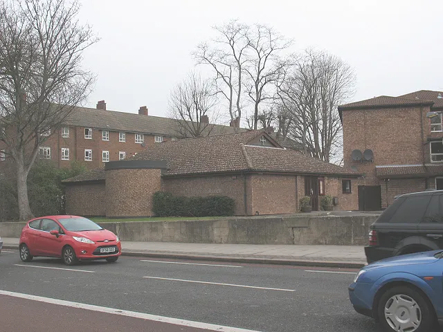 St Peter's church, Eltham Road, Lee, London SE12, seen from the southeast. Built in 1983 on the site of a previous church that had suffered structural problems almost since its completion in 1960. The block of flats behind the church, Raglan Court, was built at the same time. For the site of the original parish church see 1183139.