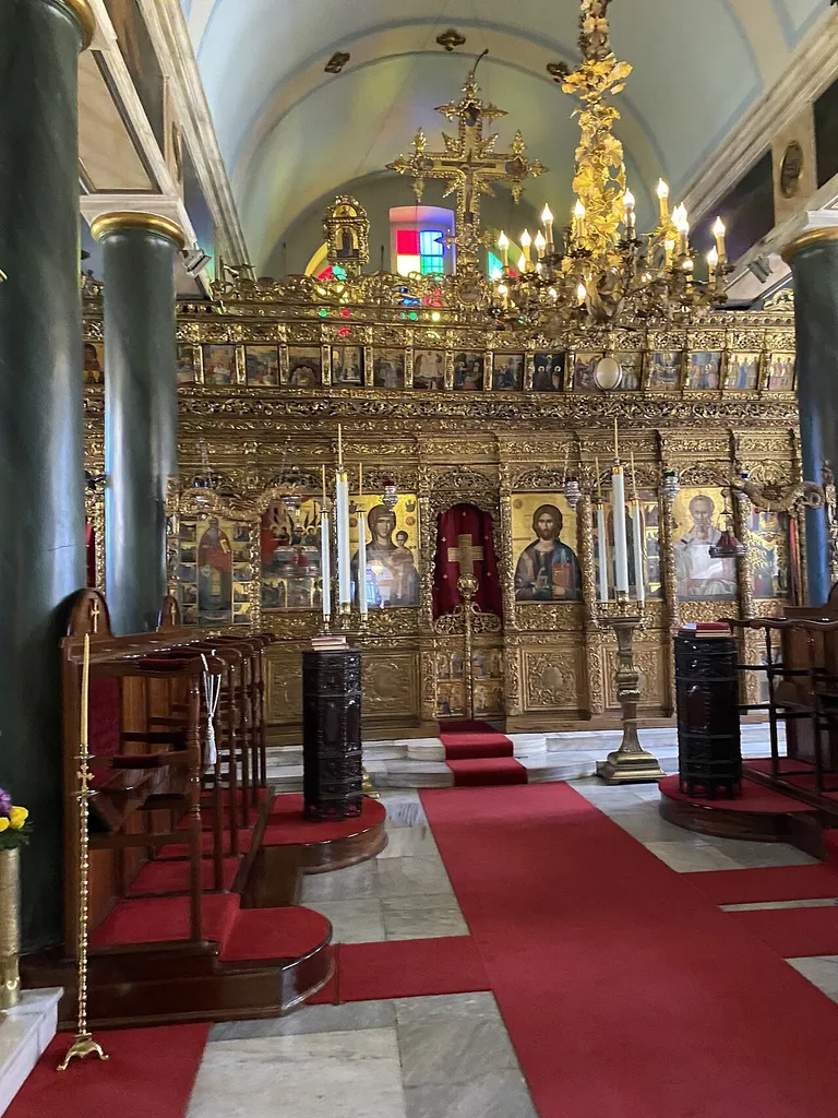 Full view of the iconostasis inside the Aya Triada (Holy Trinity) Church at the Halki Seminary (Heybeliada Ruhban Okulu), Heybeliada, Princes' Islands, Istanbul. The ornate gilt iconostasis features multiple tiers of Byzantine icons, with red and white striped walls and stained glass windows.