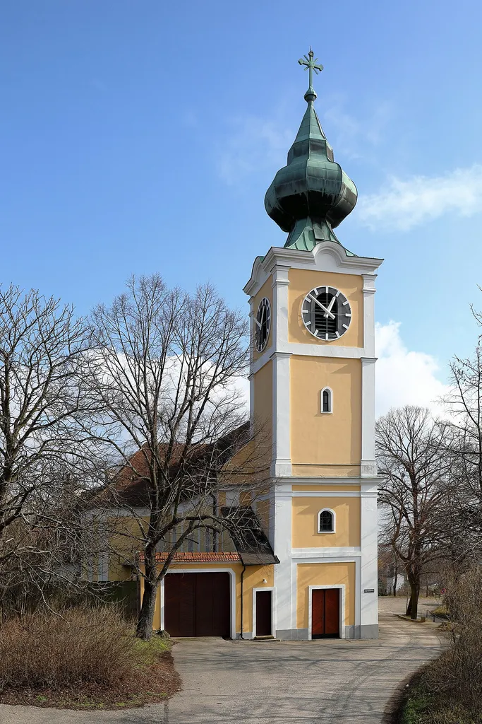 Westansicht der röm.-kath. Pfarrkirche hl. Leopold in Götzendorf, ein Ortsteil der niederösterreichischen Gemeinde Velm-Götzendorf. Die weithin sichtbare barocke Kirche wurde von 1766 bis 1772 errichtet und 1824 erweitert.