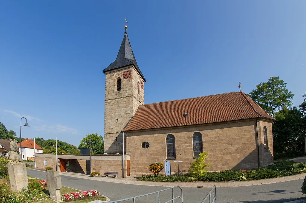 Katholische Pfarrkirche St. Wolfgang, Saalkirche mit dreiseitig geschlossenem und mit den Langhauswänden fluchtendem Chor, Sandsteinquaderbau mit Satteldach, Westturm mit Spitzhelm, spätgotische Anlage von 1468, Ausbau 1726-29, Turmhelm 1865-66; mit Ausstattung.