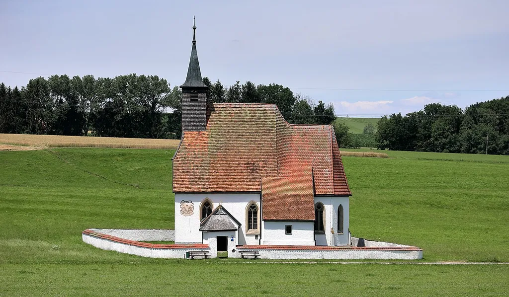 Südsüdostansicht der röm.-kath. Filialkirche hl. Michael in Kemating, ein Ortsteil der oberösterreichischen Marktgemeinde Seewalchen am Attersee. Eine kleine spätgotische Landkirche, die von einer Mauer mit Torbau umgeben ist.