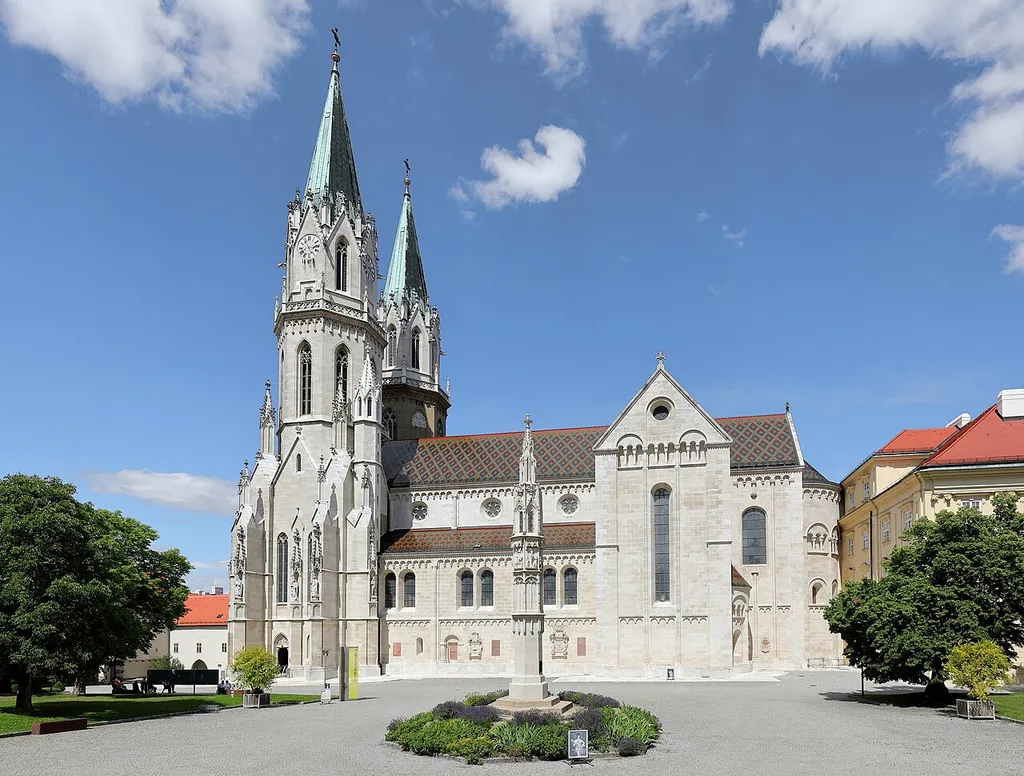 Südwestansicht der Kirche des Augustiner-Chorherren-Stiftes in der niederösterreichischen Stadt Klosterneuburg und davor die Tutzsäule.