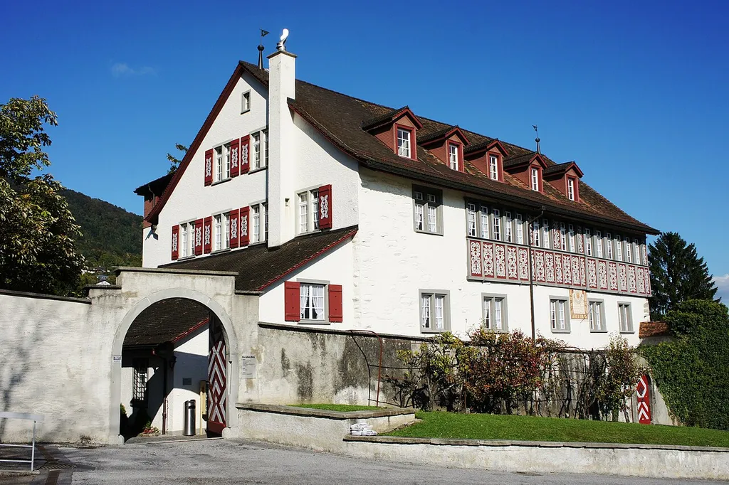 Die Burg steht nordöstlich der kath. Kirche in Rebstein. Blick aus südwestlicher Richtung auf den gemauerten Torbogen, der zum Innenhof führt. Der Hauptteil des Gebäudes ist gemauert. Der südöstliche Teil des 3. Stockwerkes besteht aus einem mit Malereien verziertem Fachwerk.