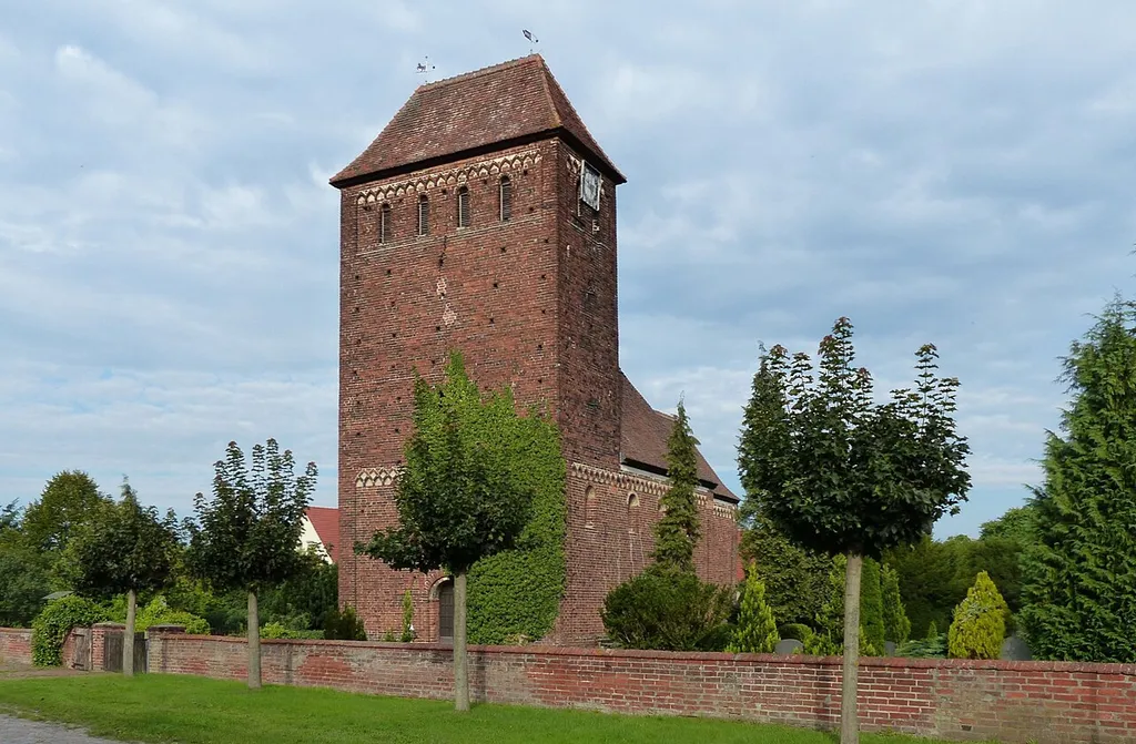 Schiff, Chor und Apsis der um 1200 errichteten spätromanischen Backsteinkirche scheinen sich hinter dem monumentalen Wehrturm hinwegzuducken - so suggeriert es jedenfalls das Bild aus der Perspektive des Fotographen. Ausdruck damals berechtigter Sorge der noch relativ jungen christlichen Gemeinden östlich der Elbe, aus ihren Dörfern wieder vertrieben zu werden. Die Melkower Kirche zeichnet sich durch vollständigen Erhalt der orginalen Bausubstanz aus; sie ist ein Kleinod spätromanischer Backsteinarchitektur in Sachsen-Anhalt.