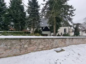 Kirche mit Kirchhof und Einfriedung, außen daran OdF-Denkmal