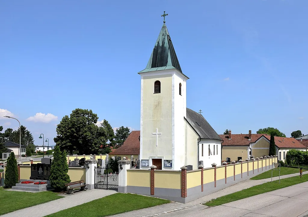 Westansicht der röm.-kath. Filialkirche Zur Kreuzerhöhung in Pframa, ein Dorf in der niederösterreichischen Marktgemeinde Eckartsau. Der schlichte barocke Bau wurde 1722 errichtet und ist von einem Friedhof umgeben.