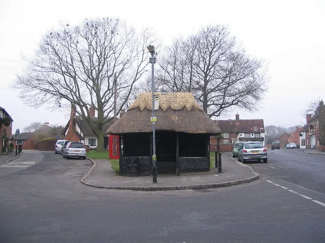 Thatched bus shelter, Dunchurch, Warwickshire. Its ridge was rethatched comparatively recently. The phone kiosk hangs from the eaves at the left. The road passing to the right is the former A45, and was before that the London-Holyhead coaching route. Another thatched shelter: 194352