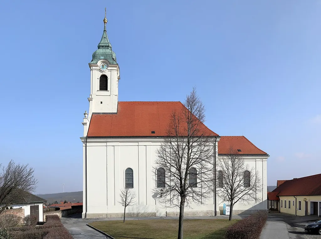 Südwestansicht der röm.-kath. Pfarrkirche hl. Martin in der niederösterreichischen Marktgemeinde Groß-Schweinbarth.Nach schweren Brandschäden (1721) der Vorgängerkirche wurde die Kirche 1934/35 neu errichtet. Der einheitliche Barockbau in erhöhter Lage war ursprünglich von einem bewehrten Friedhof umgeben.