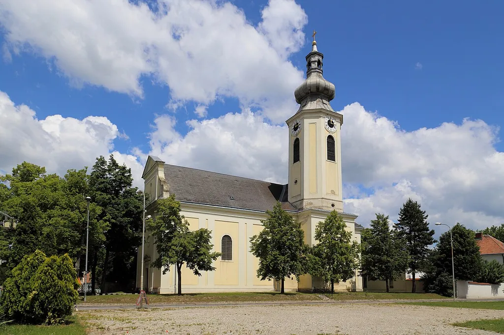 Südansicht der Pfarrkirche Mariae Himmelfahrt in der niederösterreichischen Marktgemeinde Obersiebenbrunn. Dieser großer einheitlicher Barockbau mit einem mächtigen Südturm wurde von 1722 bis 1724 in der Angermitte errichtet.