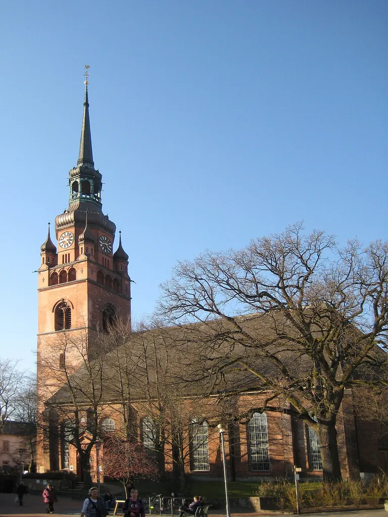 Itzehoe Stadtkirche St. Laurentii im Frühsommer. Die Kirche ist von Bäumen umzingelt und kaum abzubilden.