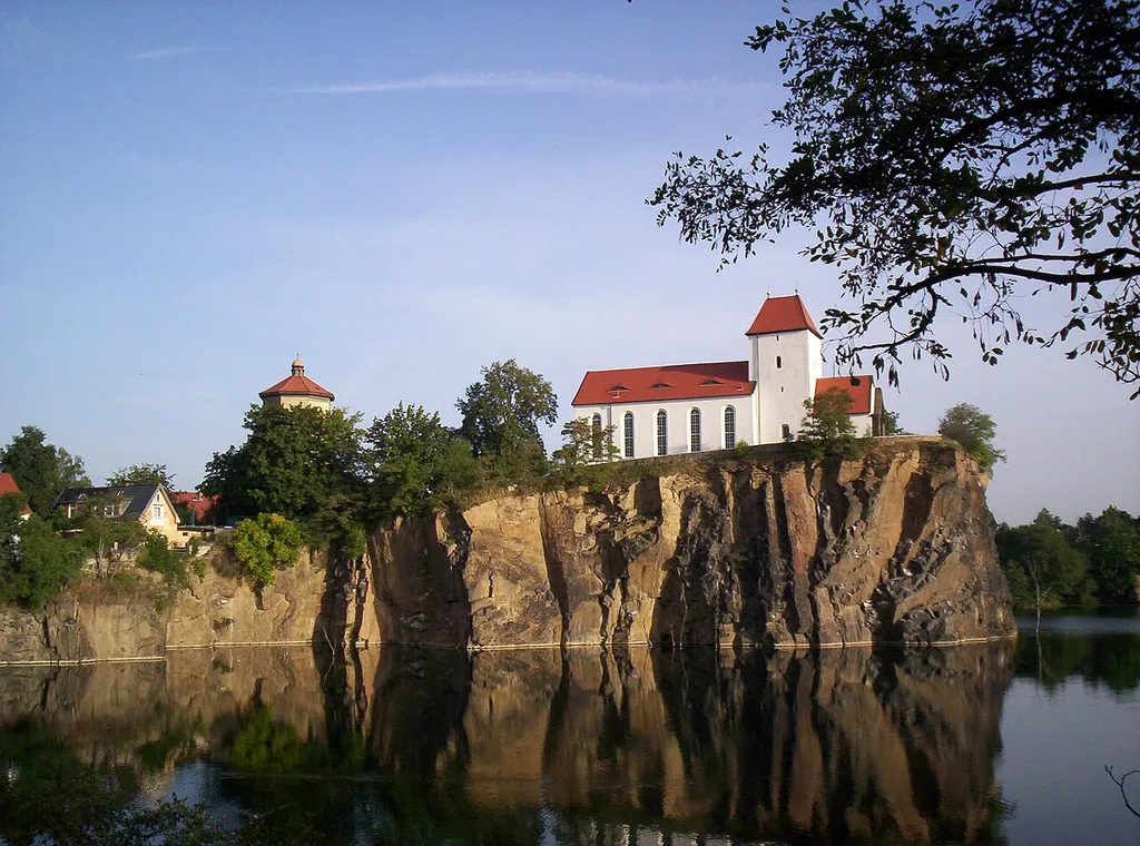 Der Kirchberg mit dem Wasserturm und der Bergkirche oberhalb des gefluteten Steinbruchs („Kirchbruch“) in Beucha, Brandis, Sachsen.