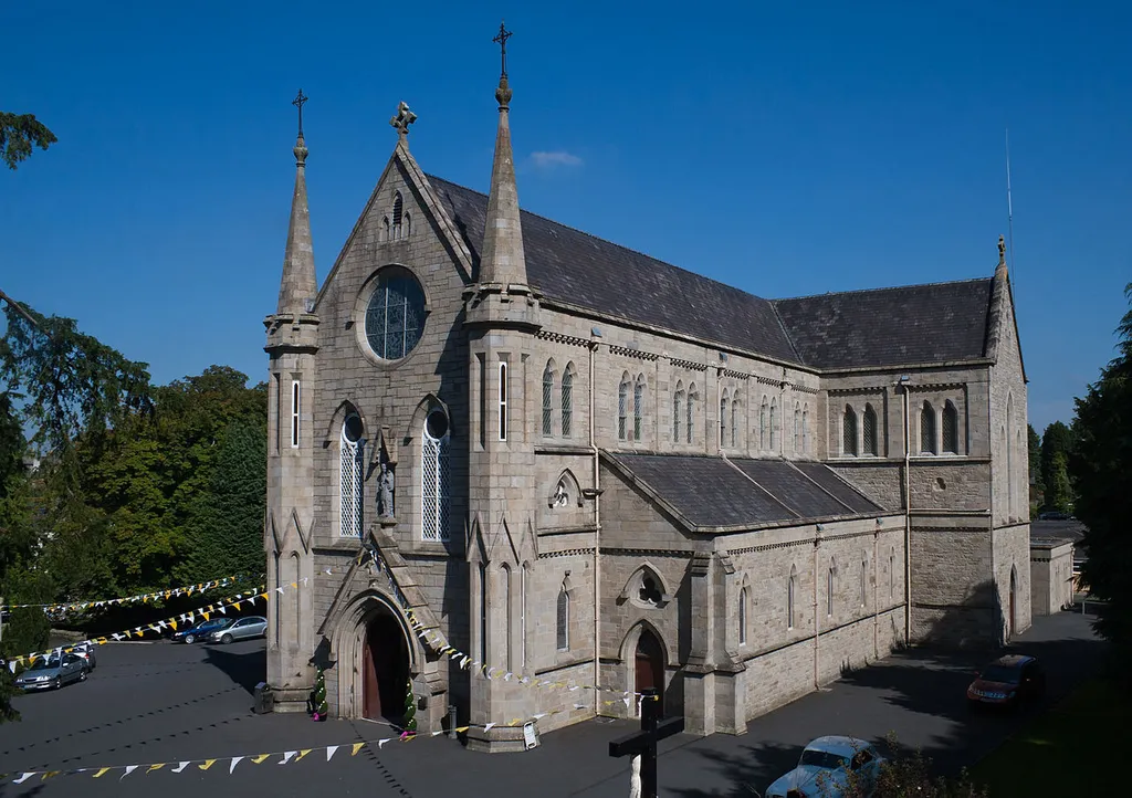 Roman Catholic Parish Church of St. Cronan in Roscrea. The construction started in 1844 to the design of the architect Dane Butler and was shortly afterwards suspended due to the famine. Construction continued under the supervision of J. J. McCarthy and was finished in 1866. The church is located at Abbey Street behind the tower and ruins of the former Franciscan friary.