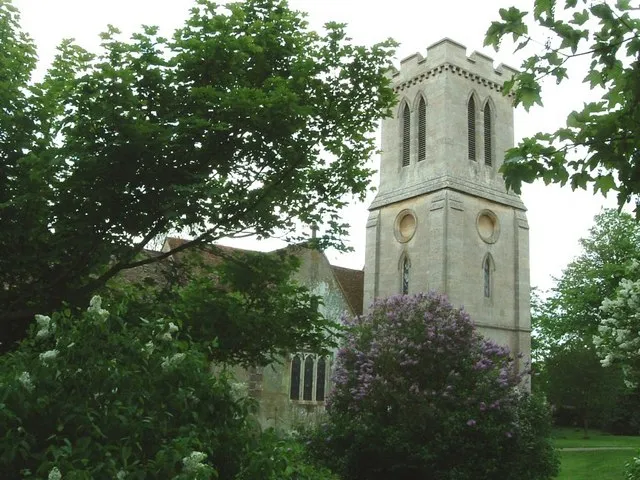Northwest tower of St Peter's parish church, Milton Bryan, Bedfordshire, seen through lilacs blooming in the churchyard