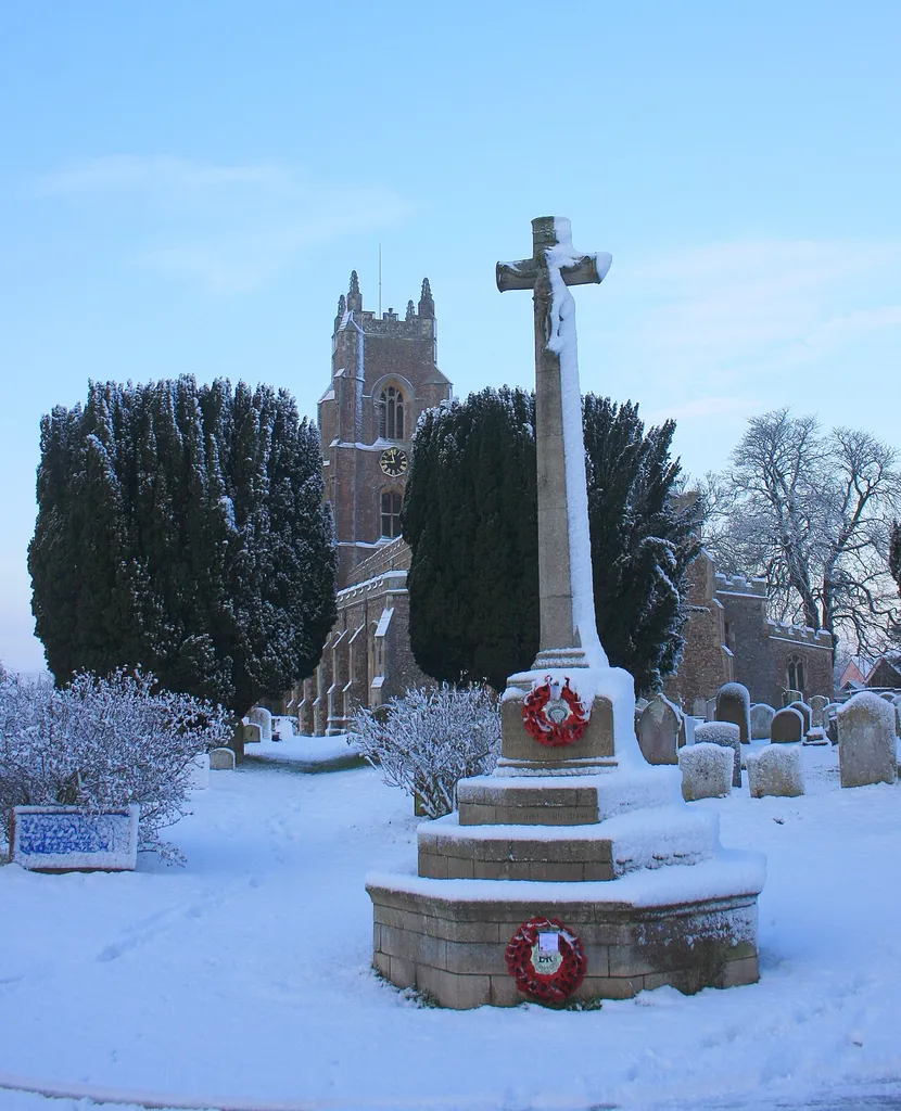 Parish war memorial in Stoke-by-Nayland, Suffolk, seen from the east, with St Mary's parish church in the background