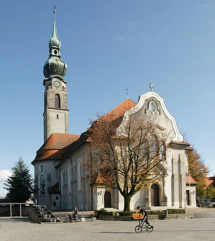 Pfarrkirche hl. Johannes dem Täufer., in Höchst (Vorarlberg). Im Norden Friedhof mit Arkaden. Mächtige neobarocke Kirche mit Querschiff, geschwungener Giebelfassade und schlankem Nord-Turm mit Zwiebelhaube. Heutiger Bau 1908-1910 nach Plan von Albert Rimli durch Baumeister Cornel Rhomberg.