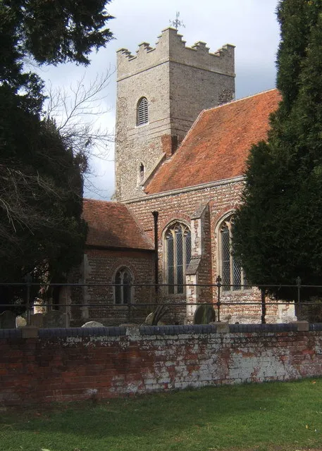 All Saints Church , Fordham, glimpsed from the road past the trees