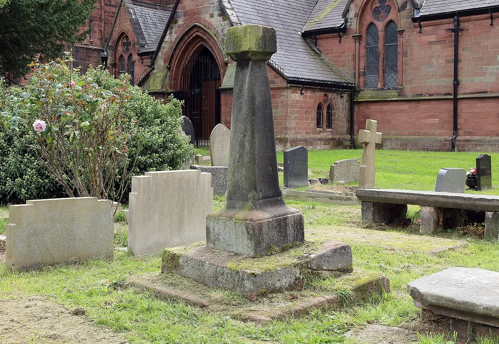 Grade II listed sundial, 1730 in the churchyard of St Barnabas, Bromborough. View showing context in relation to the church itself.
