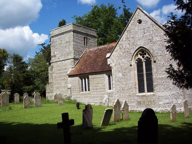 All Saints' parish church, Tarrant Monkton, Dorset, seen from the southeast. The building has walls of banded ashlar and flint with ashlar dressings, and a slate and tiled roof.