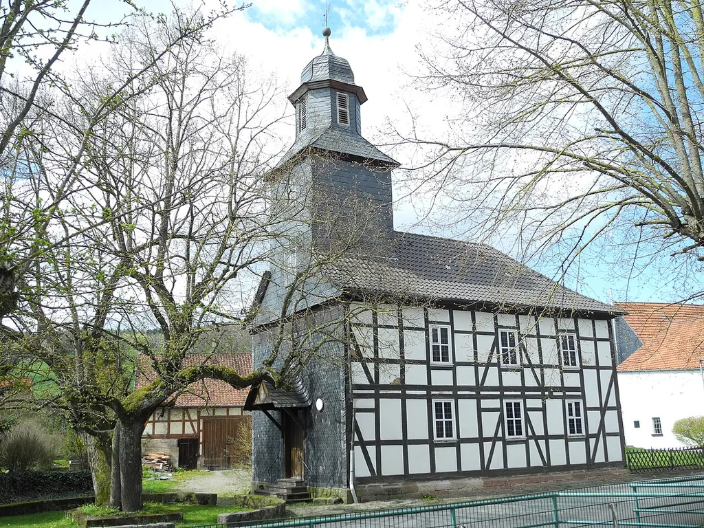 Die Kirche in Vockerode-Dinkelberg seit 1971 Stadtteil von Spangenberg, im Schwalm-Eder-Kreis, Hessen, Deutschland. Vor der Kirche steht das Naturdenkmal 634.518, eine Winterlinde (Tilia cordata).