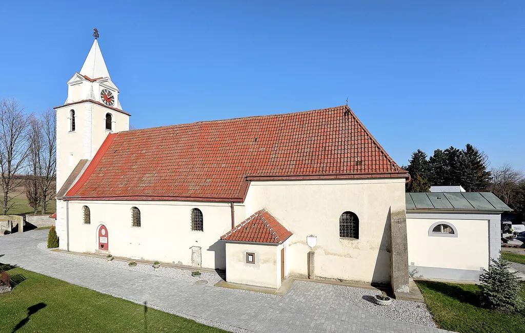Südwestansicht der röm.-kath. Pfarrkirche hl. Georg in Wienerherberg, ein Ortsteil der niederösterreichischen Gemeinde Ebergassing.Eine gotische Wehrkirche aus dem 14./15. Jahrhundert, die teilweise von einer Bruchsteinmauer umgeben ist. Die Kirche ist innen barockisiert und 1727/28 wurde nordostseitig ein Seitenschiff angebaut. Südöstlich der Kirche, direkt an den Chor angebaut, befindet sich das 1804 errichtete Mausoleum für Johann Thomas von Trattner.