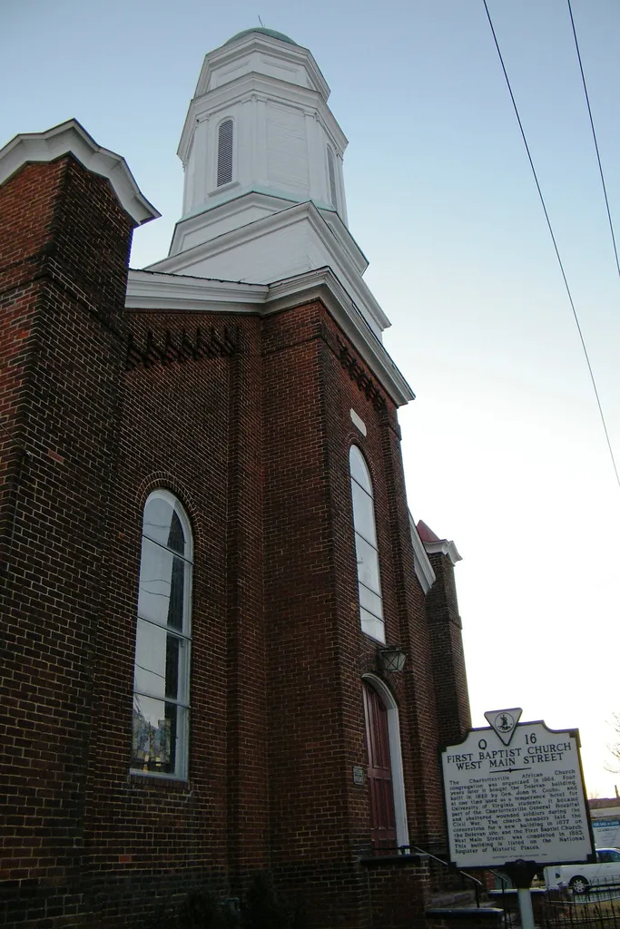 From the Historical Marker Database: The Charlottesville African Church congregation was organized in 1864. Four years later it bought the Delevan building, built in 1828 by Gen. John H. Cocke, and at one time used as a temperance hotel for University of Virginia students. It became part of the Charlottesville General Hospital and sheltered wounded soldiers during the Civil War. The church members laid the cornerstone for a new building in 1877 on the Delevan site, and the First Baptist Church, West Main Street, was completed in 1883. This building is listed on the National Register of Historic Places. This is an image of a place or building that is listed on the National Register of Historic Places in the United States of America. Its reference number is 82001802 (Wikidata).