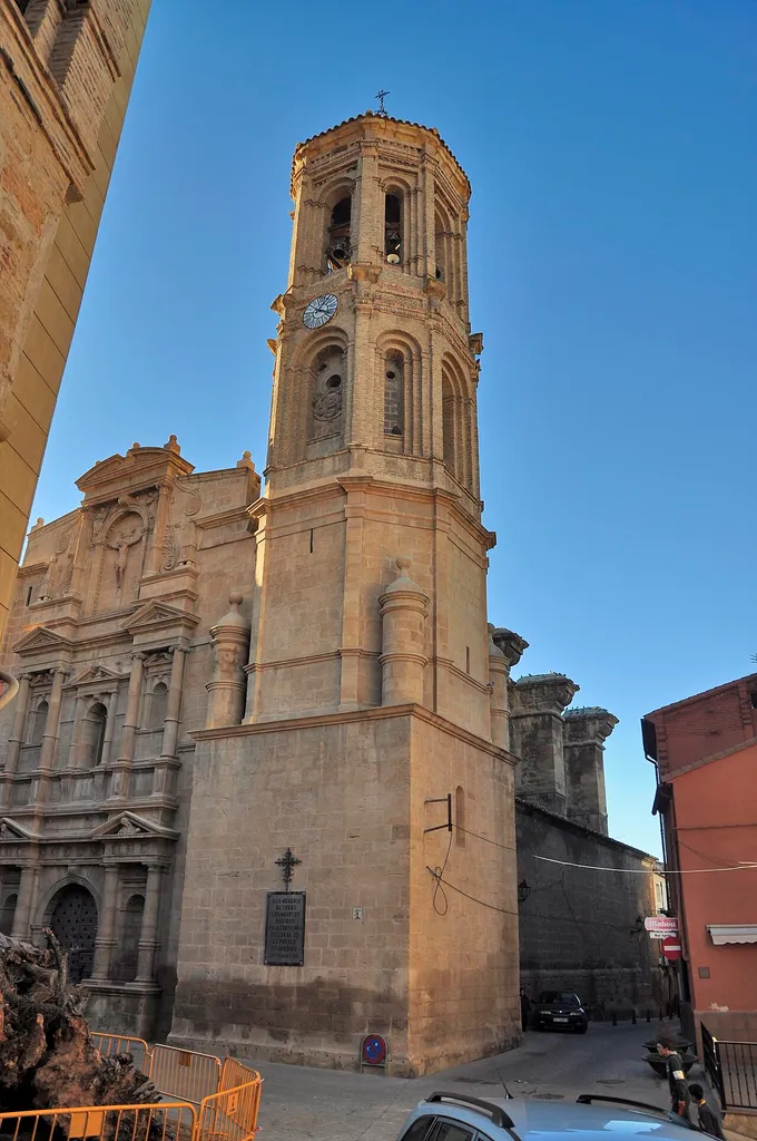 Se trata de un edificio de notables dimensiones, de nave única con capillas entre los potentes contrafuertes y cabecera recta al exterior y poligonal al interior. Fue construida entre finales del s.XVI y principios del s.XVII siguiendo un proyecto unitario. La fábrica está realizada en sillar de piedra arenisca, a excepción de la torre situada en el ángulo suroriental, que combina el sillar en sus dos cuerpos inferiores con el ladrillo en los dos superiores, fruto de una ampliación de mediados del s.XVII. En esta torre se combinan la planta cuadrada del primer cuerpo con la octogonal de los restantes, haciéndose la transición por medio de torreoncillos de ángulo. Asimismo se combinan elementos de un incipiente barroco con otros de tradición mudéjar. Al exterior destaca la fachada monumental realizada en clave manierista. Se trata de una portada-retablo articulada en dos pisos separados por un entablamento y coronados por un ático cerrado por un frontón mixtilíneo que cobija la imagen de un crucificado.