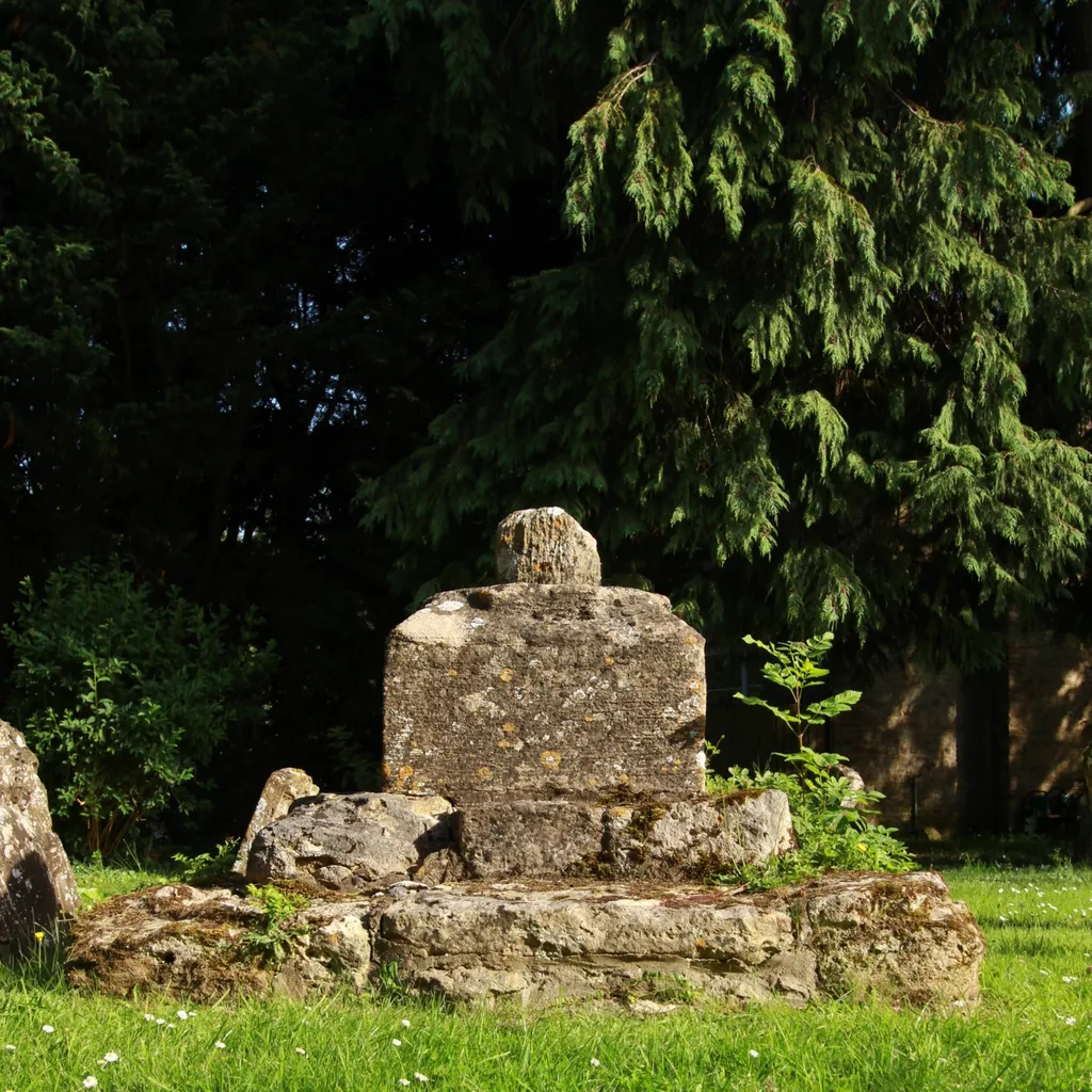 Base and broken shaft of 14th- or 15th-century stone cross in the parish churchyard of the Assumption of the Blesséd Virgin Mary, Launton, Oxfordshire, seen from north-northwest
