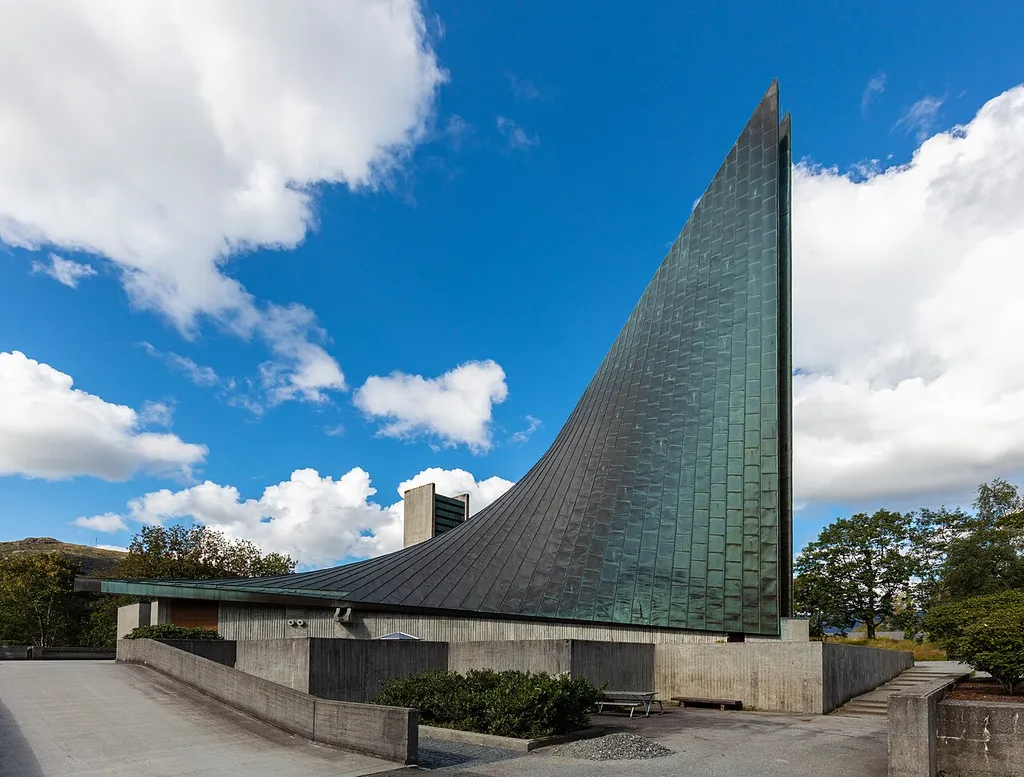 View of the particular Slettebakken Church located in the Slettebakken neighborhood, Årstad borough in the city of Bergen, Hordaland county, Norway. It's part of the Slettebakken parish in the Fana deanery in the Diocese of Bjørgvin. The large, concrete, modern-style church was built in 1970 by the architect Tore Sveram. The church, which seats up to 600 people, was consecrated on 20 December 1970 and has become a landmark in the city due to its unique curved roof line.