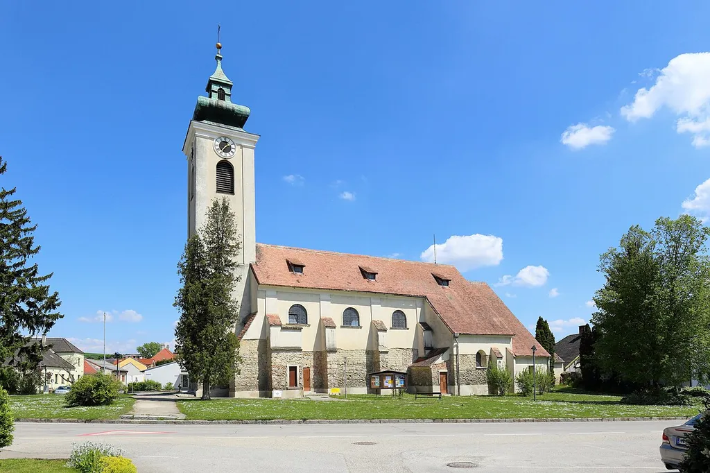Westansicht der römisch-katholischen Pfarrkirche hl. Nikolaus in der niederösterreichischen Marktgemeinde Großmugl.Eine im Kern gotische Saalkirche, die barockisiert wurde. Unter anderem wurde dabei das Langhaus erhöht. Die Marienkapelle, südseitig des Chores, wurde 1453 errichtet und 1835 erhöhte man den vorgestellte Westturm.