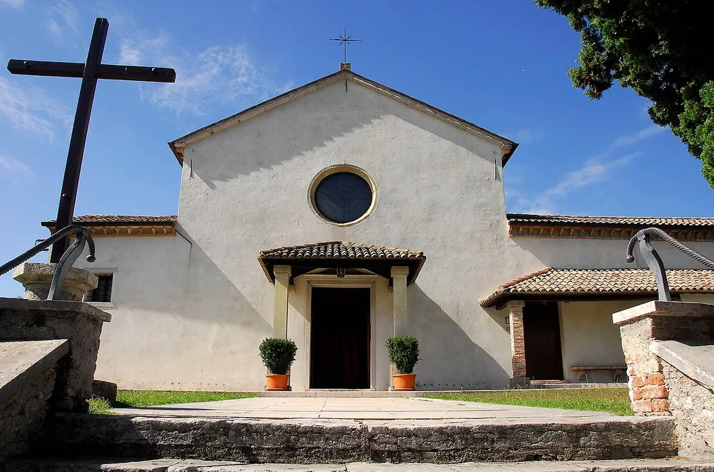 Asolo (TV), ITA - "Quando, ad Asolo, Eleonora Duse* si nascondeva in solitudine veniva quasi ogni giorno a Sant'Anna a pregare. Un banco presso l'altare, a sinistra. Là ascoltava la messa, là pregò e pianse. Mi par di scorgere, a quel banco, la forma nera, in ginocchio, col viso fra le mani. C'è ancora, ci sarà sempre. Sono molt'anni che desidero sciogliere il voto di salire da lei, quassù. Son venuta con due compagni. Dinnanzi alla chiesa di Sant'Anna sostiamo. Facciata nuda, povera, d'un grigiore scuro. Bassa, ma sembra più alta, perchè campeggia nel vuoto del cielo. Pochi scalini, e si sale al sagrato. Forse, questo di Sant'Anna è, nella sua piccolezza e umiltà, il più raccolto e solenne ch'io abbia mai veduto. Due cipressi, di diversa altezza, stanno a gurdia. Lo copre per intero, fino ai muretti di cinta, verdissima erba. Strappo, da un angolo, un pugno, due pugni d'erba: anche la zolla mi resta fra le dita. Torno alla tomba di eleonora, depongo sulla lastra i due vivissimi ciuffi misti al terriccio. Erba dunque, e terra che i piedi di lei, stanchi di tante strade ma ancor leggeri nel passo, sfiorarono quand'ella veniva alla chiesetta a pregare: solo sicuro rifugio che le fosse rimasto, verso il termine d'una vita così misera nella gloria". (Erba sul sagrato, Ada Negri) Definita meritatamente la più grande attrice teatrale di tutti i tempi, Eleonora Duse è stata un "mito" del teatro italiano: a cavallo tra la fine dell'Ottocento e i primi del Novecento, ha rappresentato con la sua profonda sensibilità recitativa e la sua grandissima naturalezza, opere di grandi autori come D'Annunzio, Verga, Ibsen e Dumas.