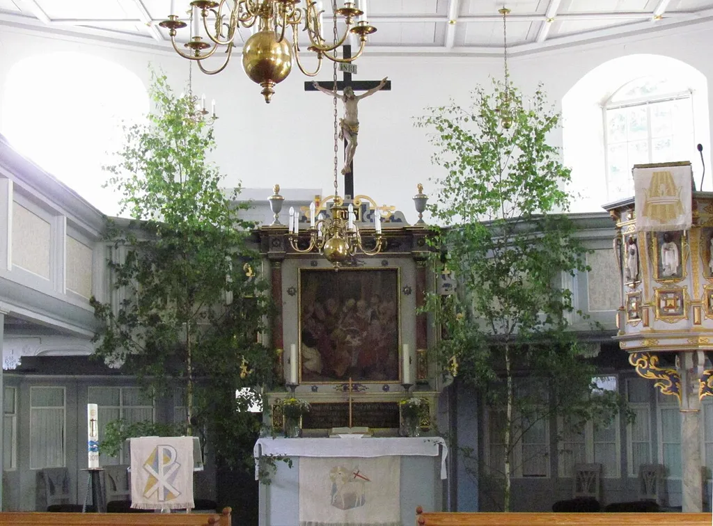 Blick zum Altar in der für das Pfingstfest mit Birken geschmückten Kirche