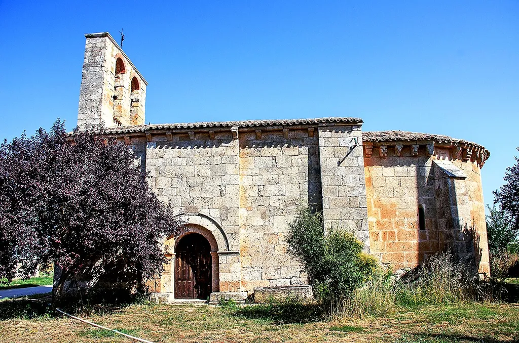 Iglesia románica de San Julián Obispo. Villanoño (Burgos - España). Fachada sur, con vista de la portada, la espadaña y el ábside.