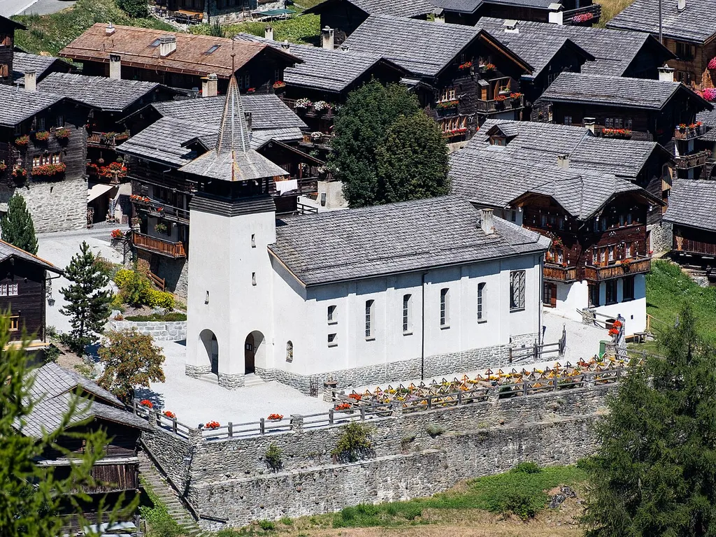 L'église de Grimentz en août 2022, vue depuis la route forestière de Grimentz.