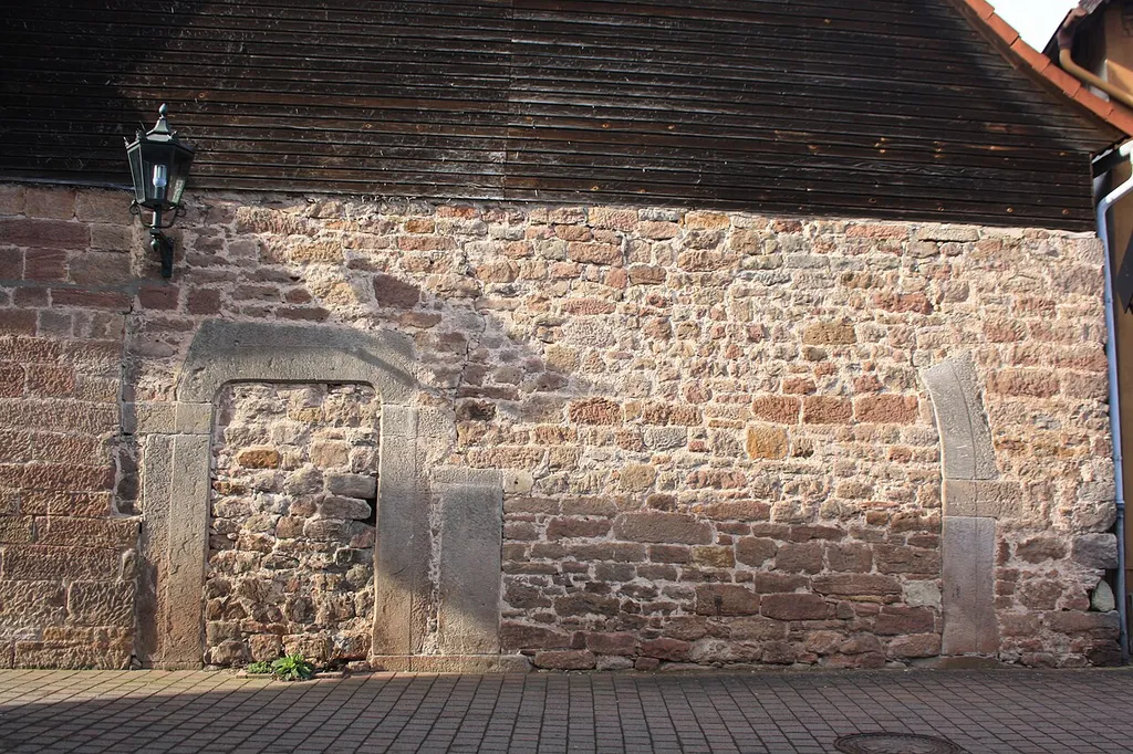 Sandsteinmauer mit erhaltenem Torbogen nahe dem Rathaus von Poppenhausen