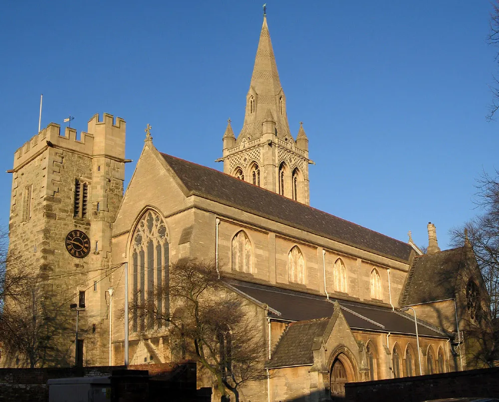 St Andrew's Church in Rugby, Warwickshire. The medieval west tower can be seen on the left. The spire of the east tower was added in the 19th century by William Butterfield.
