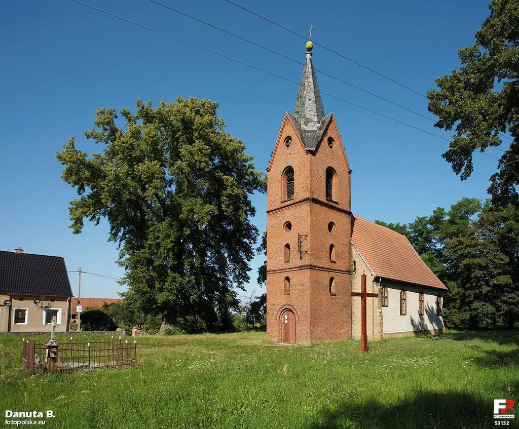 Kościół wzniesiony na wyspie wsi typu owalnica. Dawniej na terenie cmentarza był cmentarz, widać zachowany samotnie nagrobek Fritza Reiche (1891-1918).