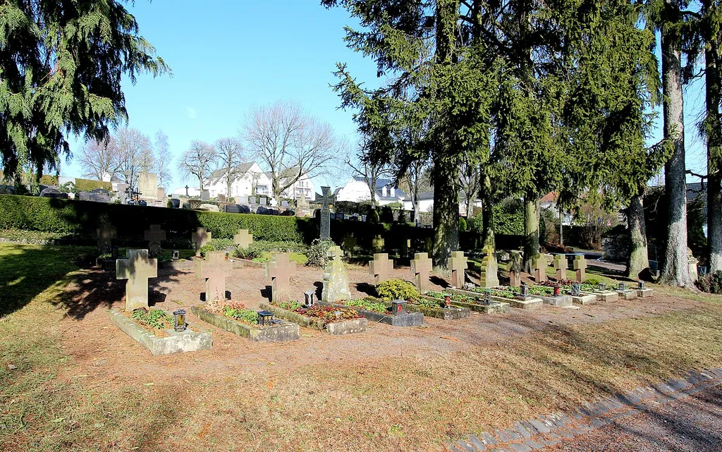 54634 Bitburg, Ecke Erdorfer Straße/Talwegangelegt. Vor 1808, ältester Grabstein: Grabmal J. und E. Holzemer († 1824 und 1808); Grabmal L. Kunkol († 1895), Sandsteinsockel, gusseiserne Inschrifttafel und Kreuz; aufwändiges Grabmal Familie Niederprüm, um 1900; Grabmal Th. Simon († 1910), Kunststein; Gefallenen-Grabmal E. Soomann († 1915); Grabmal Familie Görgen, trauernder Jüngling, um 1918; Friedhofskreuz, bezeichnet 1863; am südlichen Ausgang jüdische Grabdenkmäler, überwiegend Obelisken. Aufnahme von 2018.