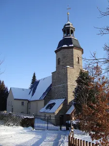 Kirche (mit Ausstattung), Kirchhof mit Einfriedungsmauer und Friedhofserweiterung mit Einfriedungsmauer und mit zwei Grabmalen (Familie Höffer und Familie Hartmann) Pfarrer-Ackermann-Platz -