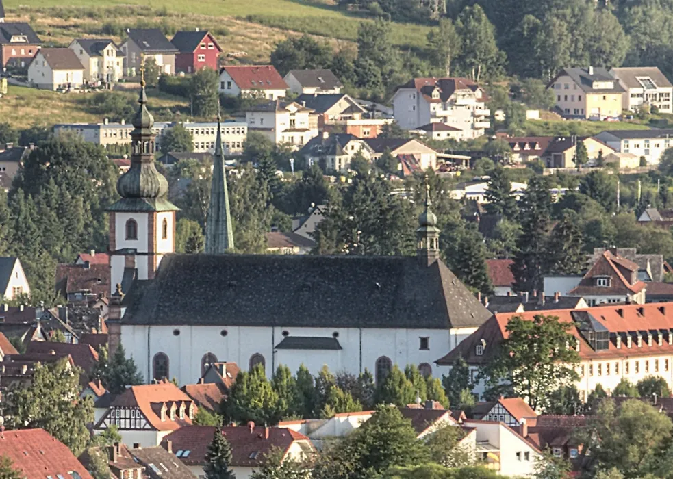 Franziskanerkloster mit der Pfarrkirche St. Peter und Paul in Salmünster. Der älteste Teil des Klosters stammt aus dem Ende des 17. Jahrhunderts. Die barocke Pfarr- und Klosterkirche St. Peter und Paul wurde zwischen 1737 und 1745 nach den Plänen des Hofbaumeisters Andreas Gallasini erbaut. Fotografiert vom Turm der Burgruine Stolzenberg
