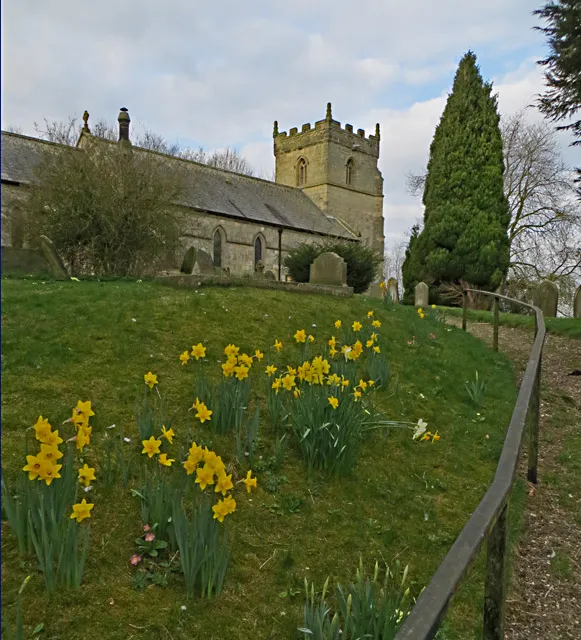 All Saints' parish church, North Dalton, East Riding of Yorkshire, England, seen from the northeast in spring.View from the path leading up to the church, parts of which, such as the nave, date from the 12th century, with an early 13th century chancel, and a 15th century west tower, the church was restored in 1872.