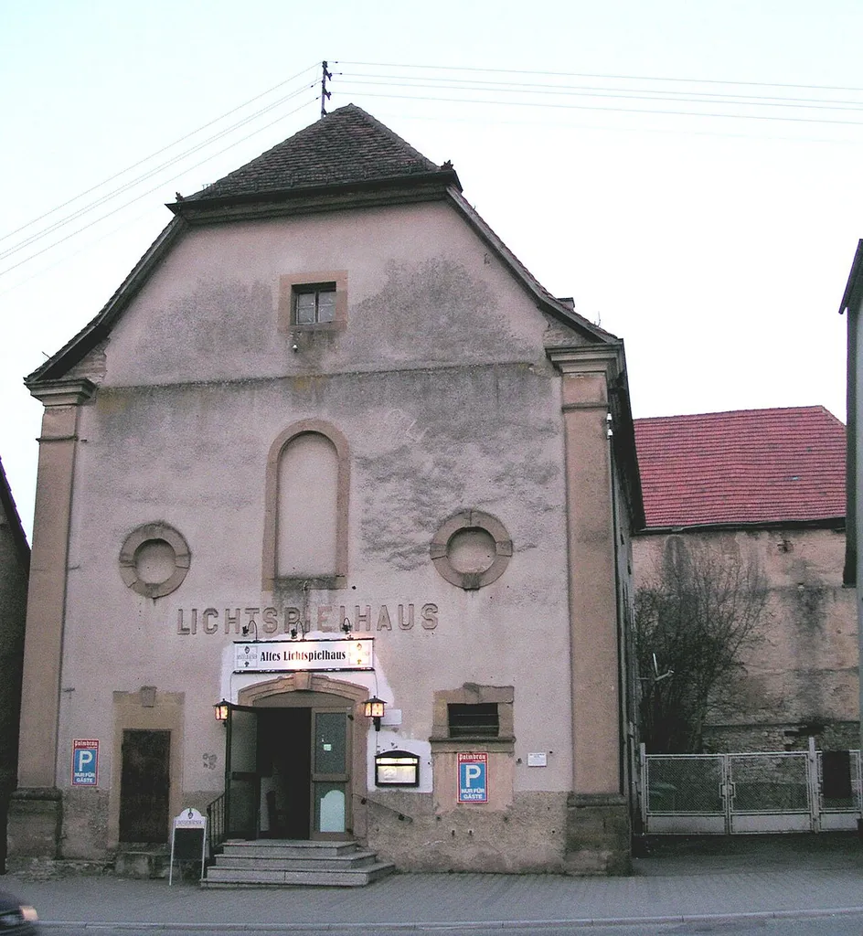 altes Lichtspielhaus von Sinsheim-Steinsfurt Die einstige reformierte Kirche ist wichtiges Zeugnis der Konfessionsgeschichte in Steinsfurt, das trikonfessionell war. Durch die kurpfälzische Kirchenteilung von 1707 hatte die reformierte Gemeinde ihr bis dahin gemeinsam mit den Katholiken benutztes Gotteshaus endgültig an diese verloren. So begann sie 1769 mit dem Bau einer neuen Kirche. Der einschiffige Massivbau wurde in barocker Formensprache als einfacher, für die Reformierten charakteristischer Predigtsaal errichtet. Gleichwohl erhielt er mit den Ecklisenen und der dreiachsig aufgebauten Eingangsfassade einen repräsentativen Anstrich, der das Gebäude unter der örtlichen Bebauung als Sonderbau hervorhebt. Mit dem Neubau der evangelischen Kirche verlor das Gebäude seine Funktion und wurde zum Kino umfunktioniert. Der Sakralbau, der trotz seiner Profanierung 1935 im Erscheinungsbild nur unwesentlich verändert wurde, ist Dokument barocker Sakralarchitektur der Region.