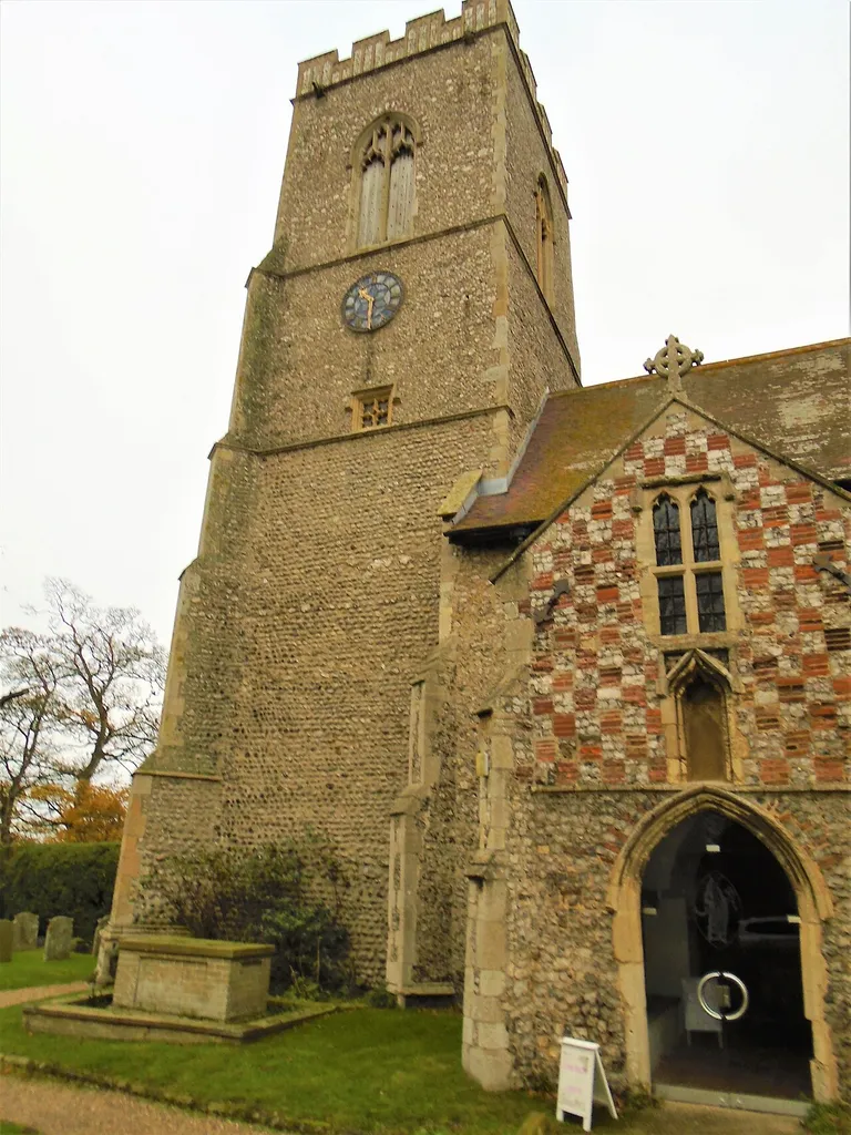 The clock tower of All saints parish church in the village of Weybourne, Norfolk, England.